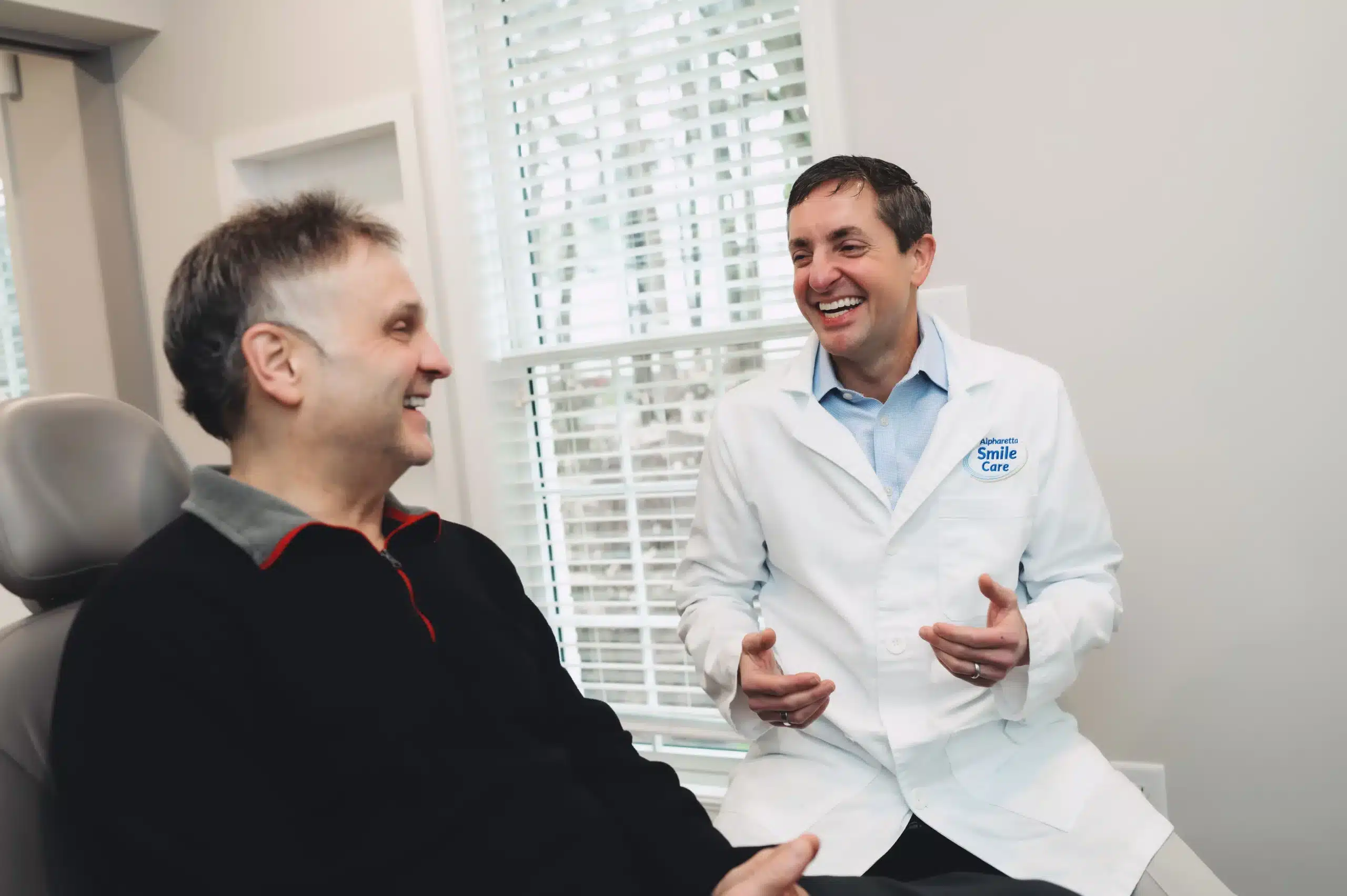 Dr. Worful chatting with a patient in the treatment chair