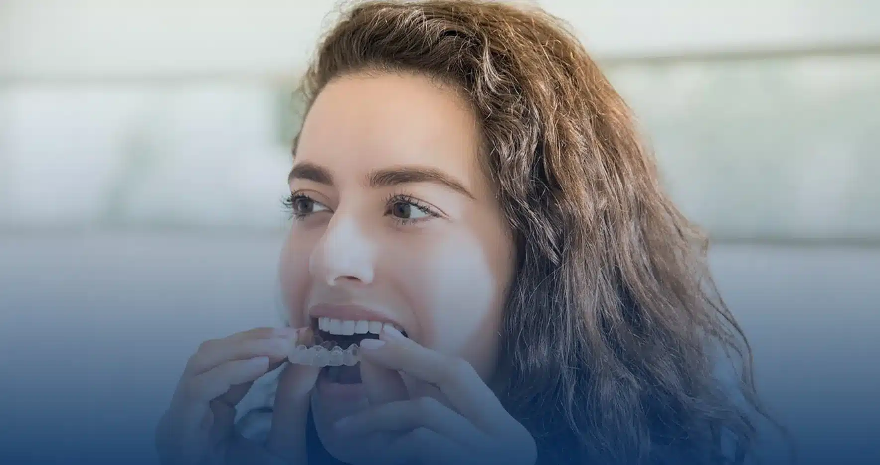Woman putting in an Invisalign clear aligner