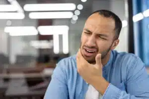 Man holding his jaw in pain from a toothache