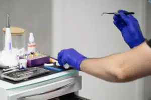 Dental instruments prepared on a tray by a gloved hand