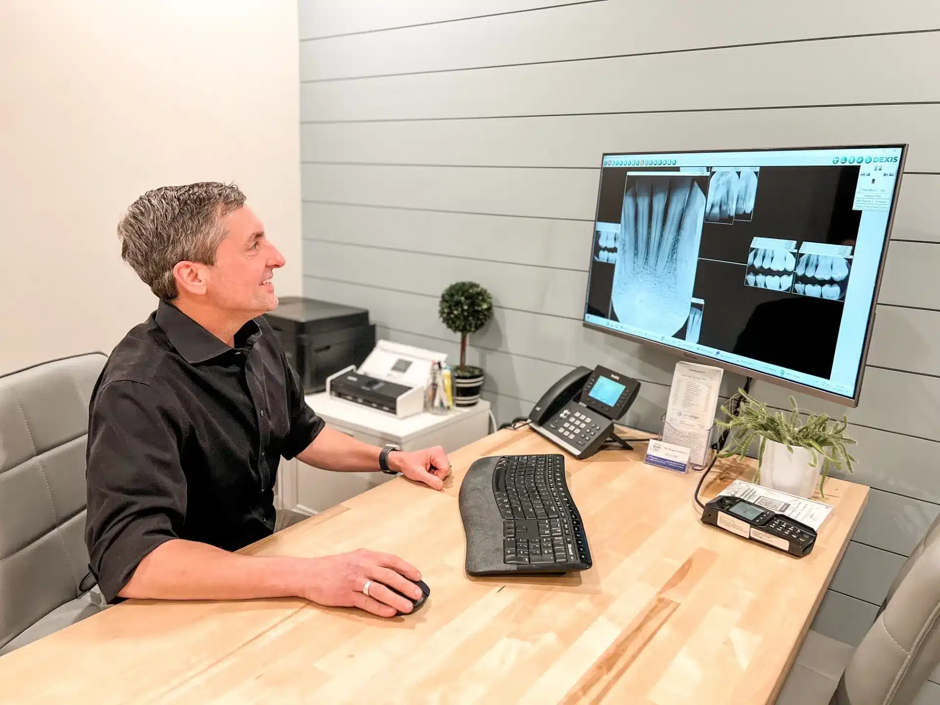 Dr. Worful reviewing dental X-rays at his desk