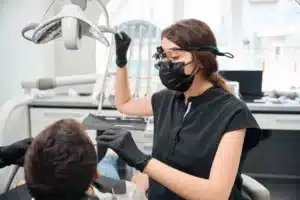 Dentist wearing loupes treating a patient