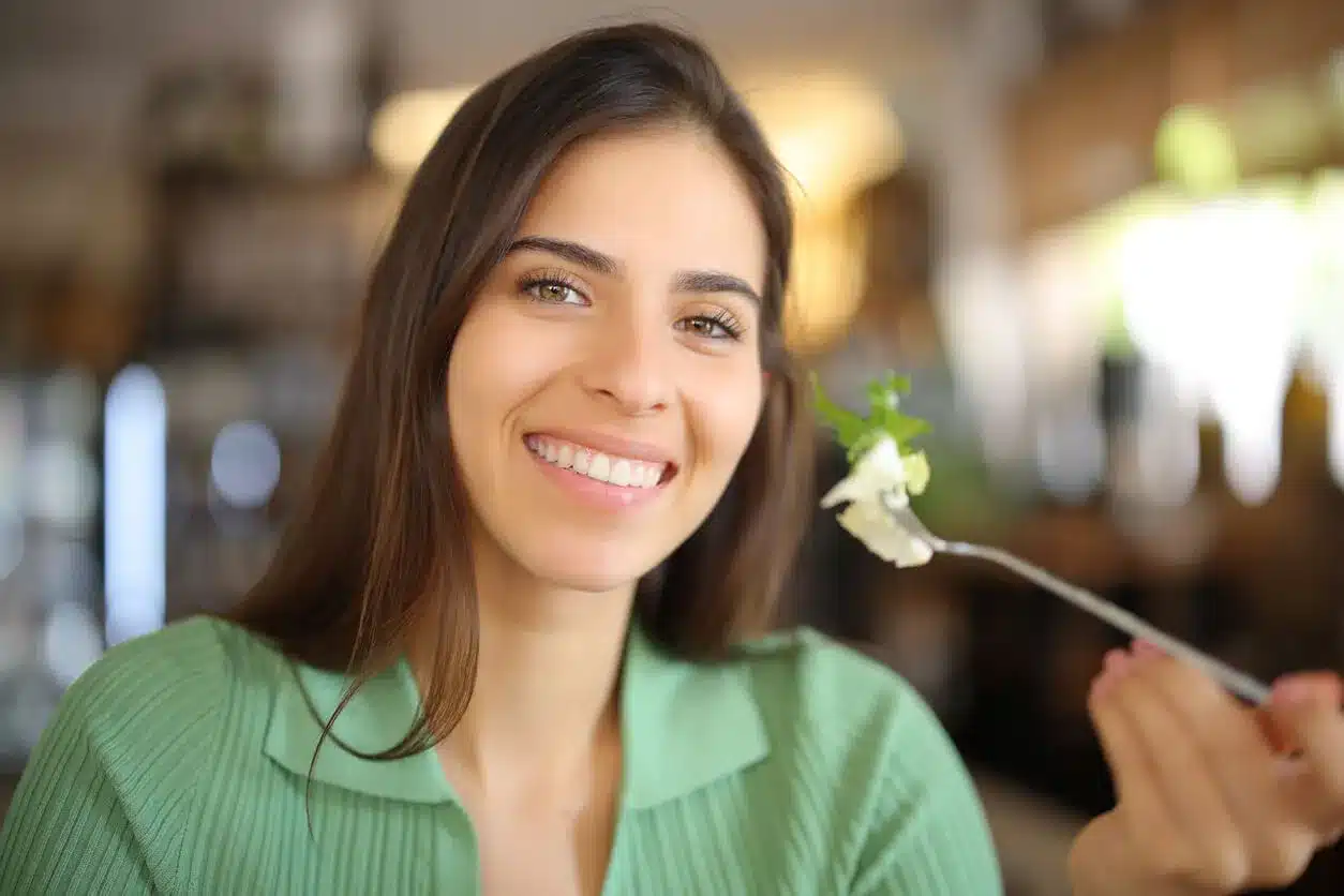 Smiling woman eating a salad