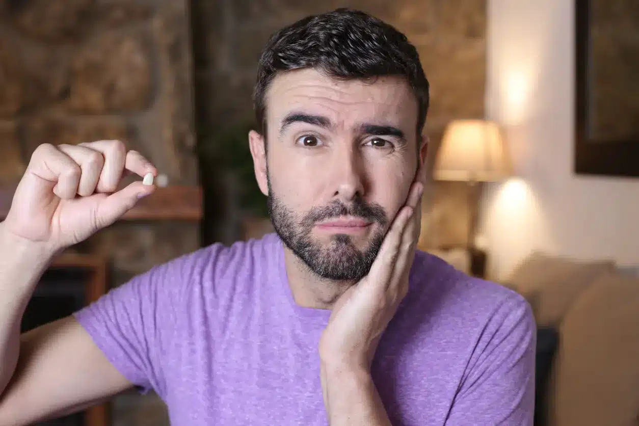 Man holding his cheek and showing a lost tooth