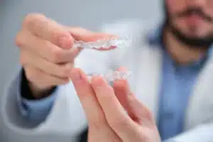 Hands holding clear Invisalign aligners