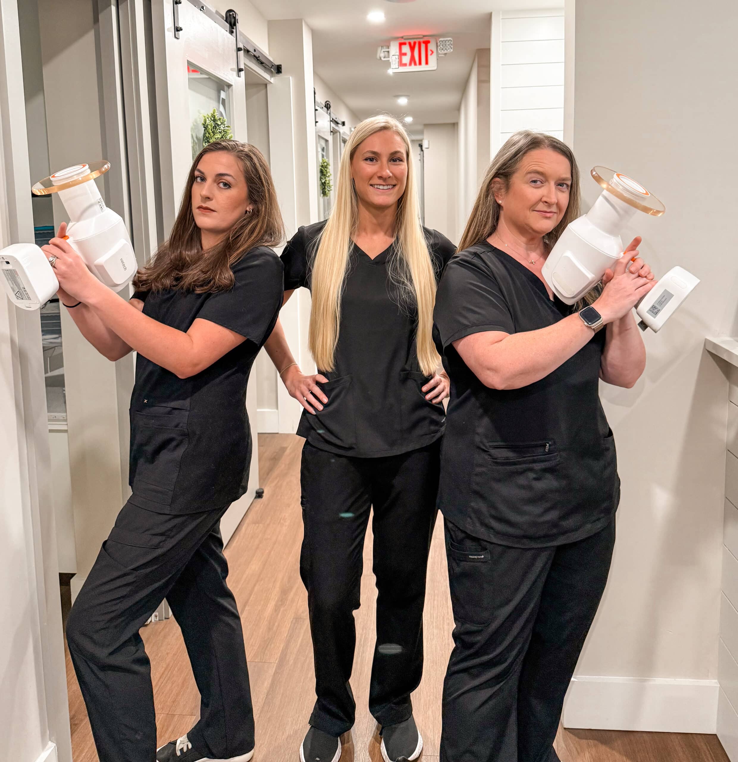 Alpharetta Smile Care team members posing in the hallway with oversized tooth props